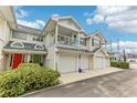 Front view of townhome with two-car garage and balcony at 505 Ashley Dr, Dunedin, FL 34698