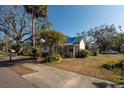 Front view of a white house with a blue tarp on the roof and a sidewalk at 7408 S Elliott St, Tampa, FL 33616