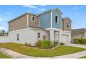 Two-story house with blue and beige siding, white garage door, and landscaping at 12804 Bent Twig Dr, Riverview, FL 33579