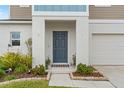 Gray front door entryway with stone border and landscaping at 12804 Bent Twig Dr, Riverview, FL 33579