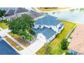 Two-story house with a lake view, and a well-manicured lawn at 3533 Juneberry Drive, Wesley Chapel, FL 33543
