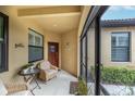 Cozy screened-in porch with wicker chairs and a small table at 417 Brandywine Falls Ct, Apollo Beach, FL 33572