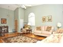 Living room with hardwood floors, comfortable seating, and large windows at 5581 Salem Square S Dr, Palm Harbor, FL 34685