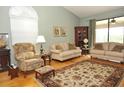 Spacious living room with hardwood floors, light walls and comfy furniture at 5581 Salem Square S Dr, Palm Harbor, FL 34685