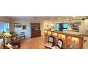 Living room with hardwood floors, built-in shelving, and a view of the kitchen at 6773 14Th N Ave, St Petersburg, FL 33710