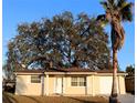 Tan house with attached garage, and large oak tree in front yard at 9116 Chantilly Ln, Port Richey, FL 34668