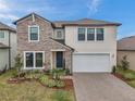 Two-story home with stone accents and a three-car garage at 22294 Storybook Cabin Way, Land O Lakes, FL 34637