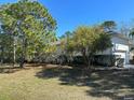 Side view of the house showing additional garage and landscaping at 3040 Sheppards Crook Ct, Holiday, FL 34691
