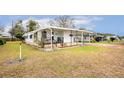 Landscaped yard with a white mobile home and covered carport at 37318 Lois Ave, Zephyrhills, FL 33542