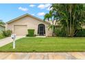 Tan house with a screened porch, garage, and well-manicured lawn at 4347 Great Lakes N Dr, Clearwater, FL 33762