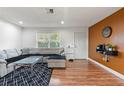 Living room with L-shaped sectional and wood-look floors at 5135 River Point Ct, New Port Richey, FL 34653