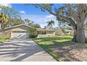 House exterior showcasing a large oak tree and driveway at 5265 Venetian Ne Blvd, St Petersburg, FL 33703