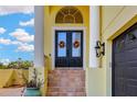 Inviting entryway with double doors, adorned with autumn wreaths, and white columns at 808 Symphony Isles Blvd, Apollo Beach, FL 33572