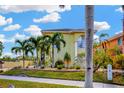 Bright two-story home with lush landscaping and mature palm trees at 808 Symphony Isles Blvd, Apollo Beach, FL 33572
