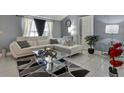 Living room with white sectional sofa and glass coffee table at 10114 Chimney Hill Ct, Tampa, FL 33615