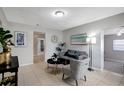 Bright living room with gray couch, patterned chair, and tile floors at 10926 N Lantana Ave, Tampa, FL 33612