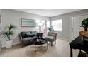 Living room features gray couch and chair, coffee table, and tile floors at 10926 N Lantana Ave, Tampa, FL 33612