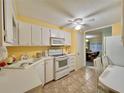 Bright kitchen with white cabinets, yellow walls, and a breakfast nook at 1100 Belcher S Rd # 190, Largo, FL 33771