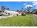 Single-story home with carport, fenced yard, and American flag at 12002 Washington St, Seffner, FL 33584