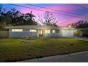 Newly renovated home with gray exterior, mature trees, and a two-car garage at 1571 Jeffords St, Clearwater, FL 33756