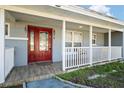 Inviting front porch with red door, white railings, and tiled flooring at 1571 Jeffords St, Clearwater, FL 33756