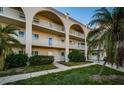 Condo building with exterior arches, neutral paint, well maintained landscape, and palm trees at 2258 World Parkway W Blvd # 8, Clearwater, FL 33763