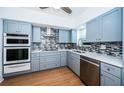 Charming kitchen featuring blue cabinets, stainless steel appliances, and modern backsplash at 2258 World Parkway W Blvd # 8, Clearwater, FL 33763