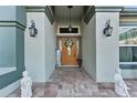 Home's entry features a wood door, lanterns, and decorative statues at 2297 Anchor Ave, Spring Hill, FL 34608