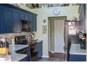 Kitchen with updated navy blue cabinets and granite countertops at 2297 Anchor Ave, Spring Hill, FL 34608