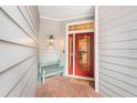 Inviting entryway with red front door and a quaint bench at 2837 Bayshore Trails Dr, Tampa, FL 33611