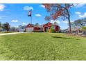 Red house with spacious yard, flag, and mature tree at 3321 Beaver Ave, Spring Hill, FL 34609