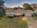 House exterior at dusk showcasing landscaping and driveway at 4345 Union Springs Rd, Spring Hill, FL 34608