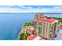 Stunning aerial view of a condo complex with red roofs, a pool, and waterfront access at 6322 Palma Del Mar S Blvd # 209, St Petersburg, FL 33715