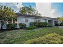Side view of the house showcasing its light gray exterior and neat lawn at 8236 Brentwood Rd, Seminole, FL 33777