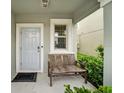 Front porch with a bench and a view of the landscaping at 9512 Lemon Drop Loop, Ruskin, FL 33573