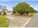 House with driveway and large tree in front at 9909 48Th N Ave, St Petersburg, FL 33708