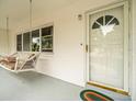 Front porch with white swing and door at 9909 48Th N Ave, St Petersburg, FL 33708