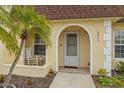 Front entryway with arched doorway, rocking chair, and palm tree at 9941 85Th St, Seminole, FL 33777