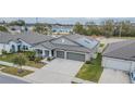 One-story home with gray exterior, two-car garage, solar panels, and landscaped yard at 10832 Sage Canyon Dr, Riverview, FL 33578