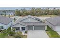 One-story home with gray exterior, two-car garage, solar panels, and landscaped yard at 10832 Sage Canyon Dr, Riverview, FL 33578