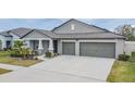 One-story home with gray exterior, two-car garage, and landscaped yard at 10832 Sage Canyon Dr, Riverview, FL 33578