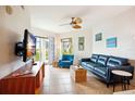 Living room with blue sofa, wooden tv stand and ocean view at 11605 Gulf Blvd # 302, Treasure Island, FL 33706