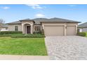 Single story house with three car garage and paver driveway at 13008 Weatherstone Dr, Spring Hill, FL 34609