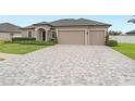 Single-story house with three-car garage and landscaped yard at 13008 Weatherstone Dr, Spring Hill, FL 34609