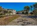 Two-story house with a long driveway and palm trees in the front yard at 1302 Belcher Dr, Tarpon Springs, FL 34689