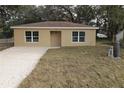 Newly built tan house with gravel driveway and grassy yard at 156 Grand Ave, Brooksville, FL 34604