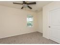 Empty bedroom with carpeted floor, ceiling fan, and window at 17048 Oval Rum Dr, Wimauma, FL 33598