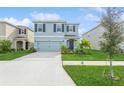 Two-story house with light blue exterior, two-car garage, and landscaped front yard at 17048 Oval Rum Dr, Wimauma, FL 33598