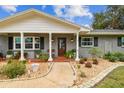 Inviting front entrance with a wood door, brick facade, and landscaping at 3400 Lake Padgett Dr, Land O Lakes, FL 34639