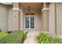 Front entrance with double doors and brick columns at 7473 Willow Brook Dr, Spring Hill, FL 34606